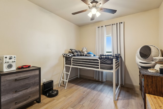 bedroom featuring ceiling fan, baseboards, and wood finished floors