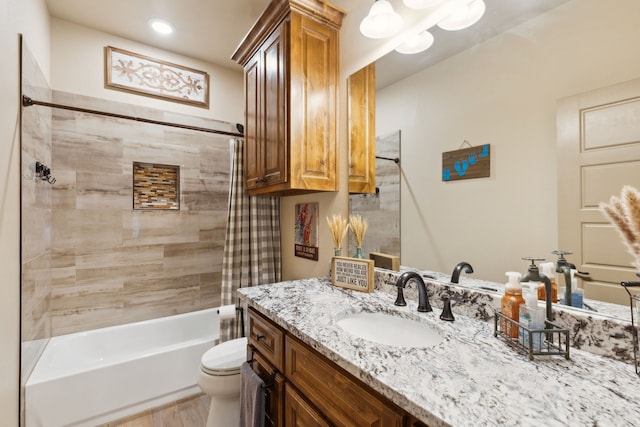 full bathroom featuring wood finished floors, bathing tub / shower combination, vanity, and toilet