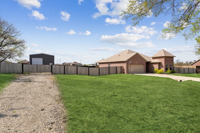 view of yard with fence, a garage, and concrete driveway