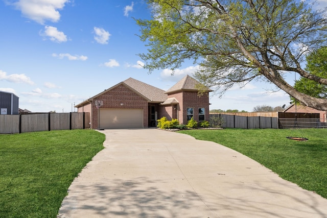 traditional home with a garage, driveway, fence, a front yard, and brick siding