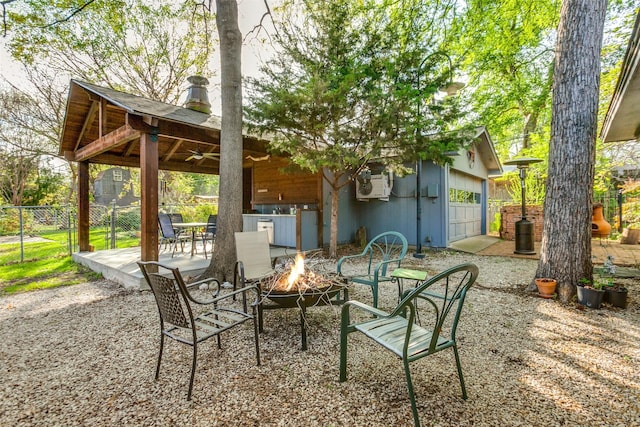 view of patio / terrace with a gazebo, a ceiling fan, an outdoor fire pit, and fence