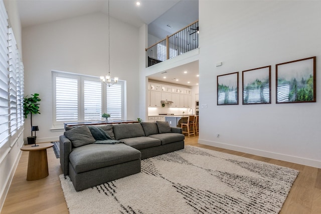 1716 Bradford Pear Way, Celina, TX 75078 - living area with a chandelier, light wood-style flooring, baseboards, and a towering ceiling