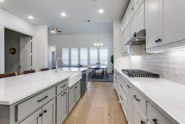1716 Bradford Pear Way, Celina, TX 75078 - kitchen featuring appliances with stainless steel finishes, a sink, a chandelier, under cabinet range hood, and light wood-type flooring