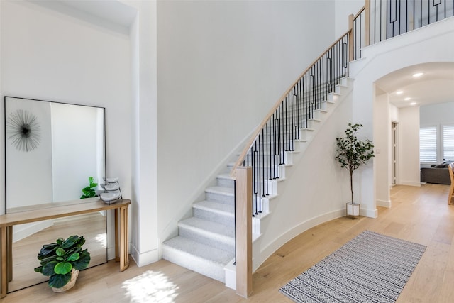 1716 Bradford Pear Way, Celina, TX 75078 - stairway featuring wood finished floors, arched walkways, a towering ceiling, and baseboards
