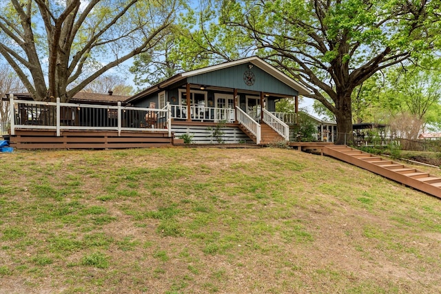 view of front of property featuring a wooden deck and a front lawn