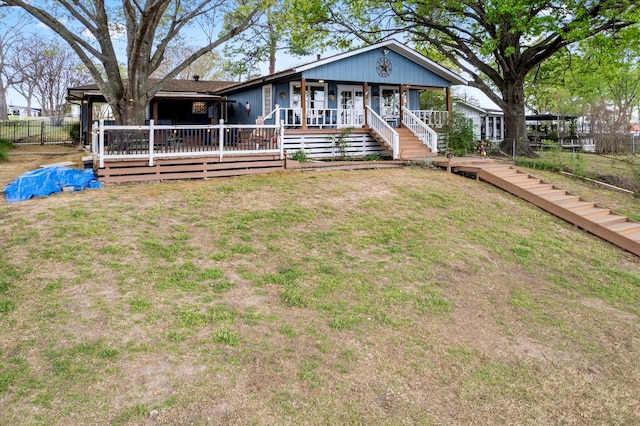 bungalow-style house with a porch, fence, and a front lawn