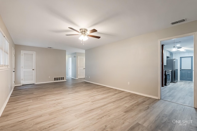 unfurnished room with ceiling fan, light wood-type flooring, and baseboards