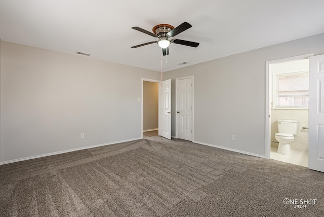 unfurnished bedroom featuring carpet, ensuite bathroom, baseboards, and ceiling fan