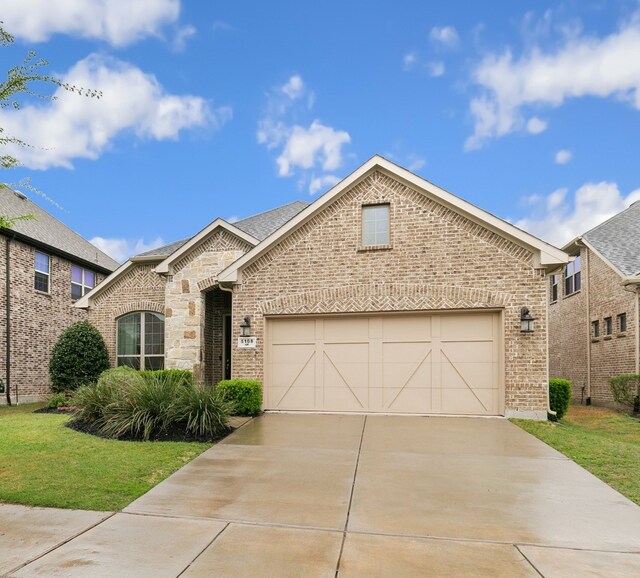 view of front of property with a front yard, stone siding, brick siding, concrete driveway, and an attached garage