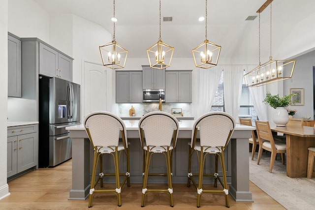 5108 Shallow Pond Dr, Little Elm, TX 76227 - kitchen with gray cabinetry, appliances with stainless steel finishes, a chandelier, light countertops, and high vaulted ceiling