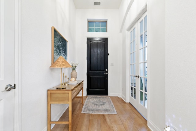 entrance foyer with visible vents, wood finished floors, and baseboards