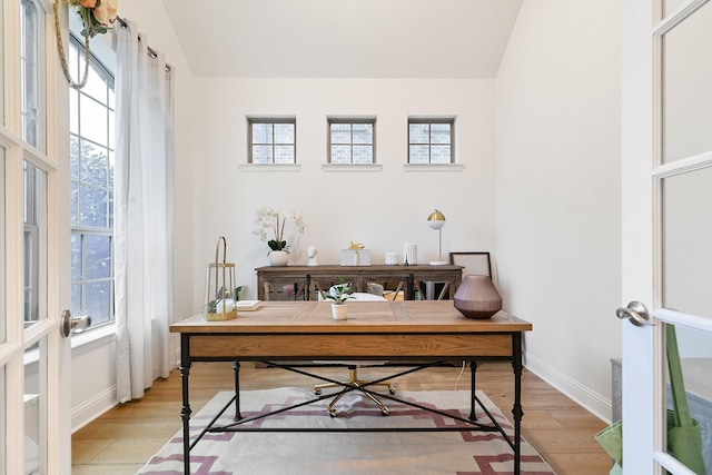 office area featuring light wood-type flooring, french doors, and vaulted ceiling