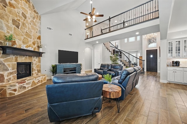 living area with visible vents, stairway, a fireplace, and wood finished floors