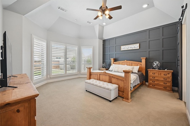 bedroom featuring a decorative wall, lofted ceiling, light colored carpet, and visible vents