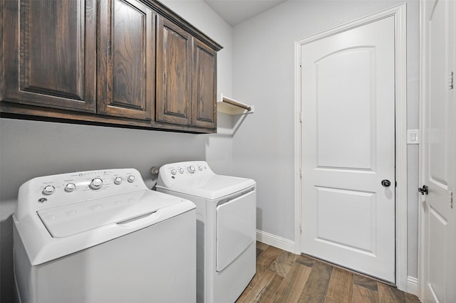 washroom featuring independent washer and dryer, cabinet space, dark wood-style floors, and baseboards