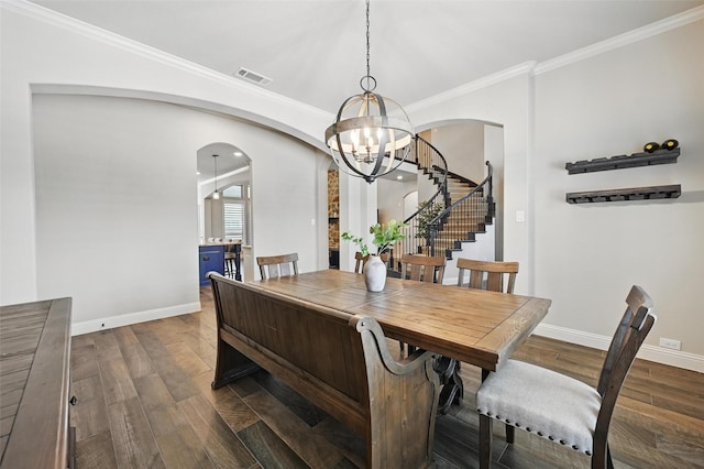 dining room with arched walkways, dark wood-style floors, visible vents, and stairway