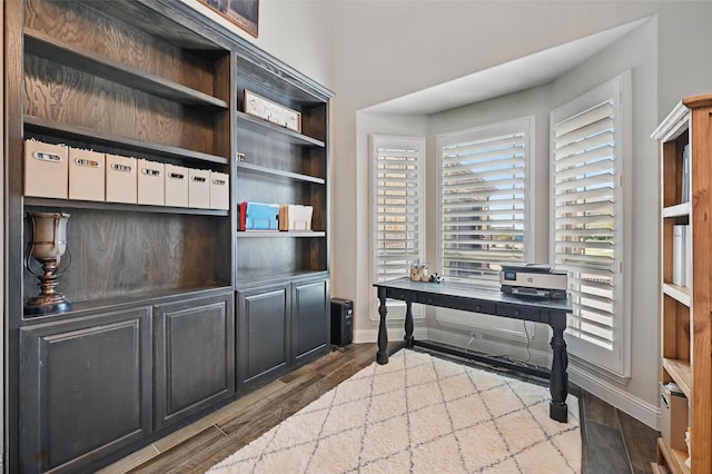 home office with baseboards and wood finished floors