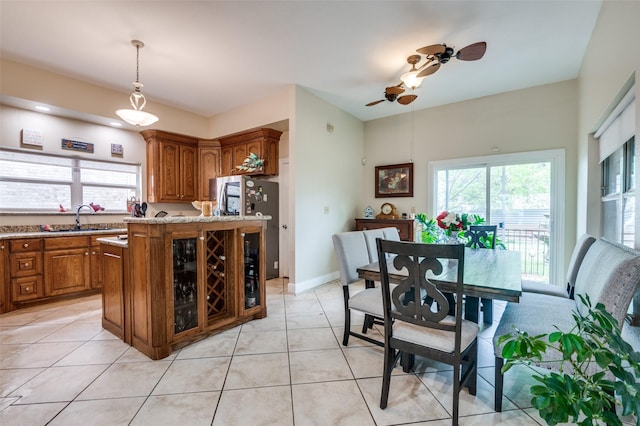 1207 Stafford St, Dallas, TX 75208 - kitchen featuring brown cabinetry, a sink, healthy amount of natural light, and pendant lighting