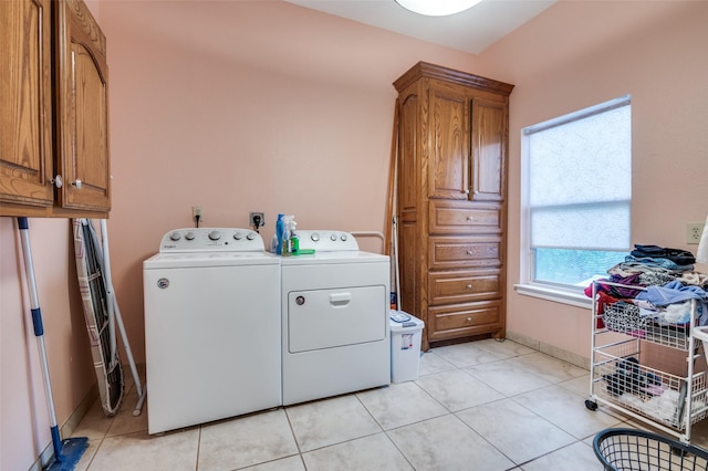 1207 Stafford St, Dallas, TX 75208 - laundry area featuring washing machine and clothes dryer, cabinet space, light tile patterned flooring, and baseboards