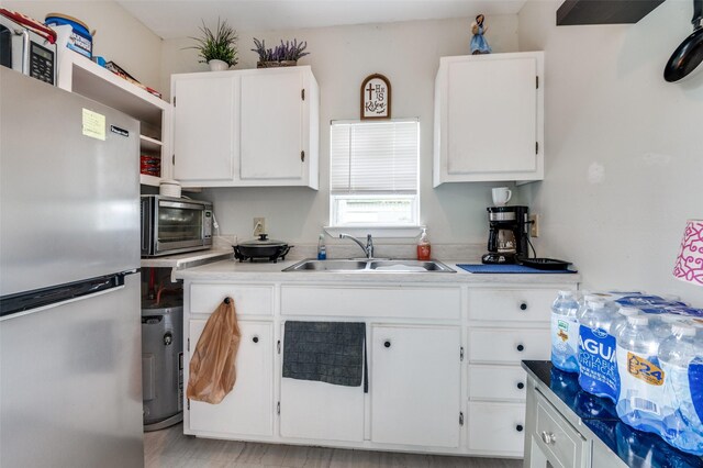 1207 Stafford St, Dallas, TX 75208 - kitchen with freestanding refrigerator, a sink, white cabinets, open shelves, and light countertops