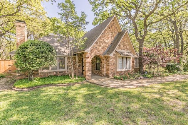 2111 Meadowview Dr, Keller, TX 76262 - tudor house with brick siding, a front lawn, roof with shingles, and fence