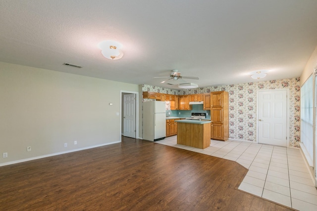 2111 Meadowview Dr, Keller, TX 76262 - kitchen with light wood-style flooring, a center island, visible vents, baseboards, and white appliances