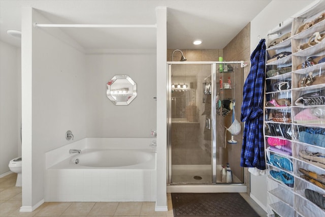 bathroom featuring a bath, tile patterned floors, a shower stall, and toilet