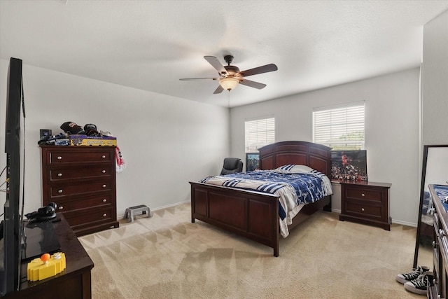 bedroom with light colored carpet, ceiling fan, and baseboards