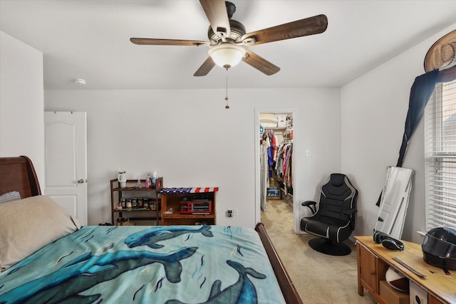 carpeted bedroom with a spacious closet, ceiling fan, and a closet