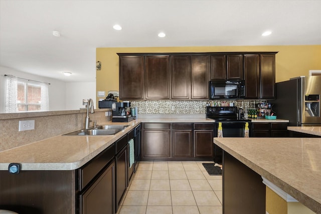 kitchen with a sink, dark brown cabinetry, decorative backsplash, black appliances, and light tile patterned floors