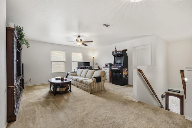 carpeted living room with visible vents, baseboards, and ceiling fan