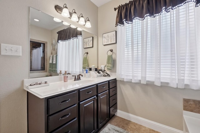 full bath with baseboards, vanity, and tile patterned floors