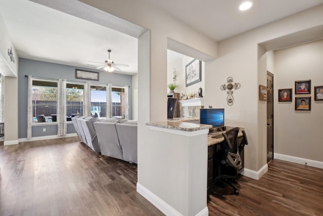 living room featuring a ceiling fan, baseboards, and wood finished floors