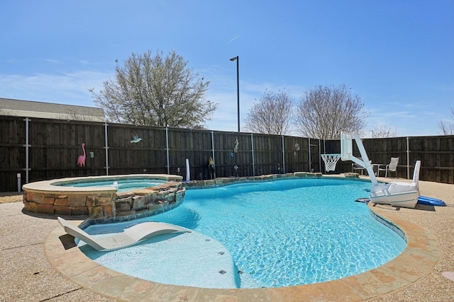 view of swimming pool with a fenced backyard and a pool with connected hot tub