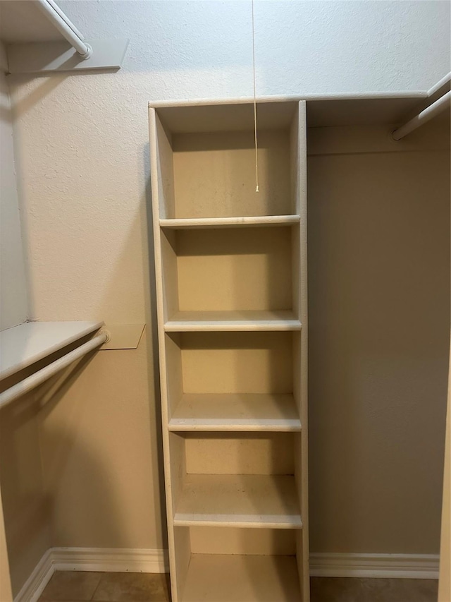 walk in closet with tile patterned floors