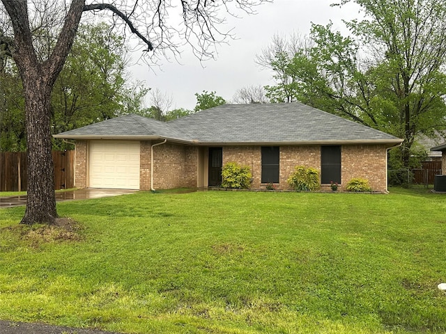 ranch-style house featuring a garage, a front yard, fence, and brick siding