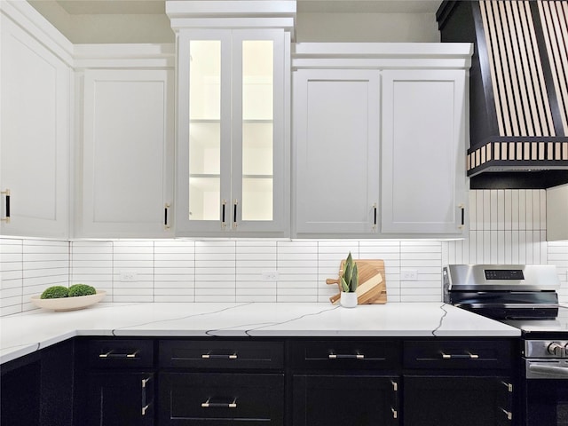 kitchen featuring dark cabinets, tasteful backsplash, electric stove, and wall chimney range hood