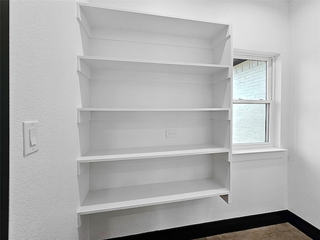 interior details with a textured wall and baseboards