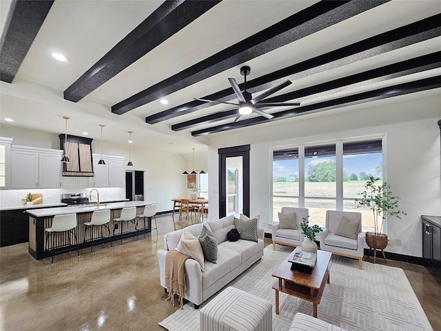 living area featuring baseboards, recessed lighting, a ceiling fan, beamed ceiling, and concrete flooring