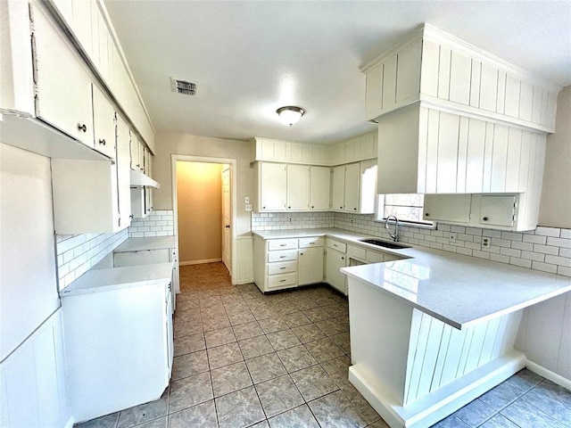 140 Vz County Road 2153, Canton, TX 75103 - kitchen with a sink, a peninsula, backsplash, under cabinet range hood, and light countertops