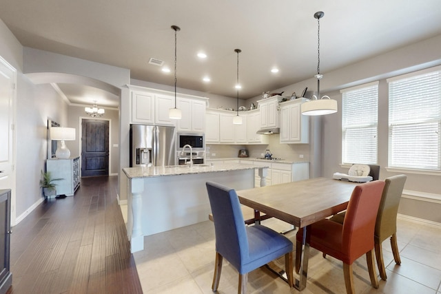 dining room with visible vents, baseboards, recessed lighting, and arched walkways