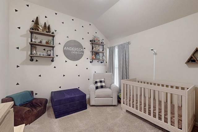 bedroom with a crib, carpet floors, and lofted ceiling