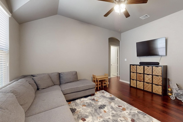living room with ceiling fan, arched walkways, vaulted ceiling, visible vents, and wood finished floors