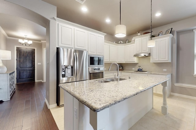 kitchen with appliances with stainless steel finishes, a sink, white cabinets, and under cabinet range hood