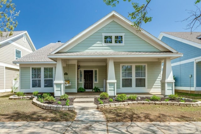 view of front of home with roof with shingles and covered porch