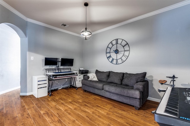living room featuring arched walkways, wood finished floors, visible vents, and ornamental molding