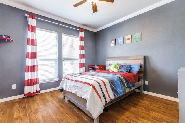 bedroom with baseboards, wood finished floors, ceiling fan, and crown molding