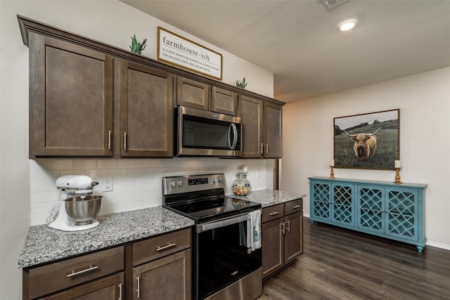 kitchen with tasteful backsplash, light stone counters, dark wood-style floors, dark brown cabinets, and stainless steel appliances
