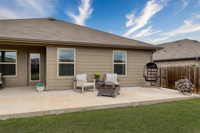 rear view of house featuring a patio area, fence, a fire pit, and a yard