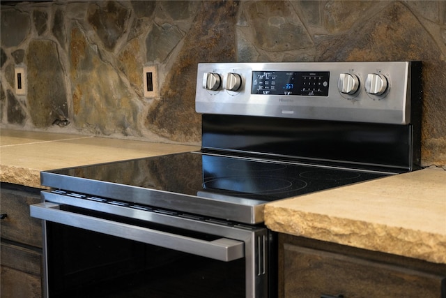 room details with stainless steel electric range, tasteful backsplash, light countertops, and mail area